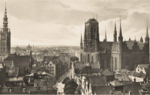 Zdjęcie czarno-białe. Miasto Gdańsk, widok na ulicę Piwną. Z lewej fragment wieży Ratusza. Po prawej części Bazylika Mariacka.