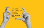 Plakat. Na żółtym dwie widać dwie dłonie. Ułożone w sposób, w jaki trzyma się aparat i naciska przycisk wyzwalacza. Pomiędzy dłońmi czarny napis Konkurs Fotograficzny Muzeum Gdańska Mój Gdańsk 2020.