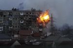 Wielopiętrowy blok mieszkalny w Mariupolu. Wybuch pocisku na 6-7 piętrze budynku. Ze ściany bucha ogień, lecą odłamki.