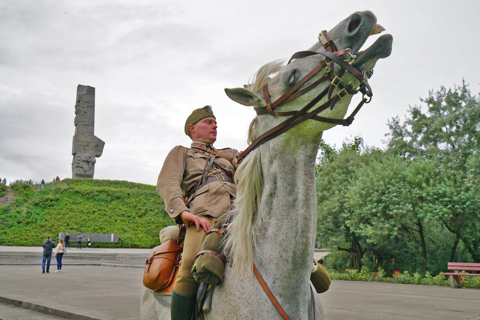 Jeździec na koniu w mundurze generała wojska polskiego z II Wojny Światowej. W oddali widać Pomnik Obrońców Wybrzeża.