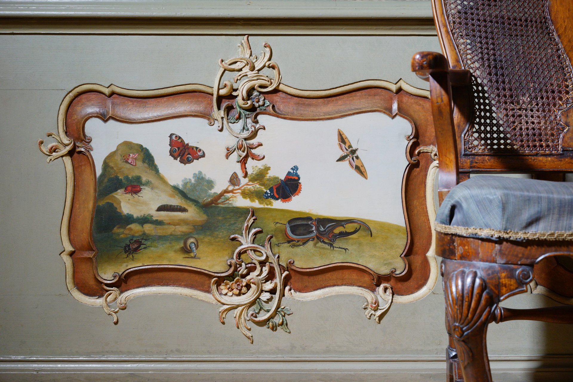 Malunek na lamperii. Owady na trawie: motyle, chrabąszcz, ćma, gąsienica, żuki. Po prawej fragment krzesła.